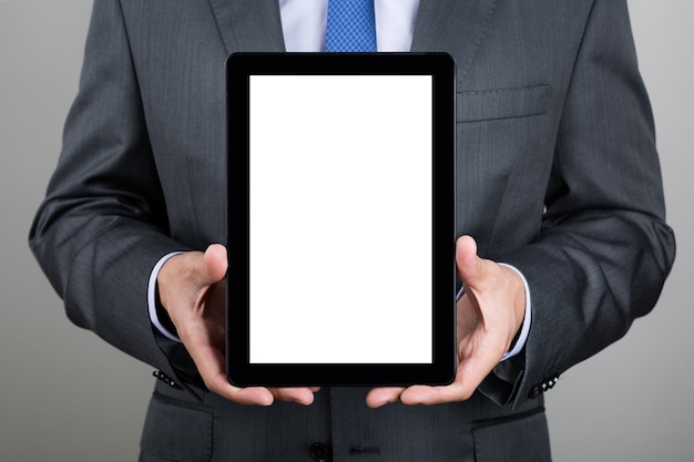 Business man holding digital tablet PC showing something on blank screen. Copyspace.