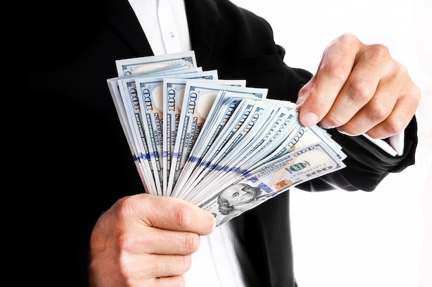 Business man holding money on white wall