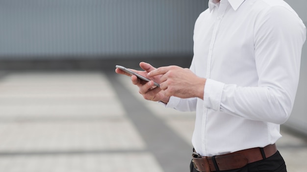 Foto alto vicino del telefono della holding dell'uomo di affari