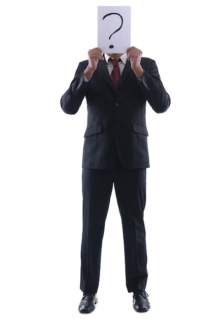 Business man holding a piece of paper over his face with a question mark on it isolated on white background in studio