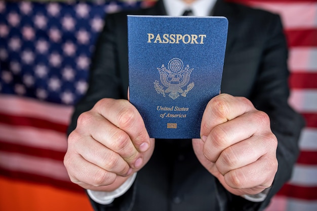 Foto uomo d'affari che tiene e legge il passaporto usa