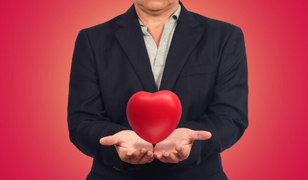 Business man holding red heart ball for Valentine day