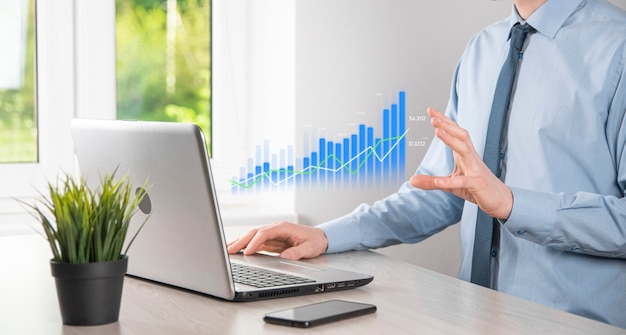 Business man holding tablet and showing holographic graphs and stock market statistics gain profits. Concept of growth planning and business strategy. Display of good economy form digital screen.