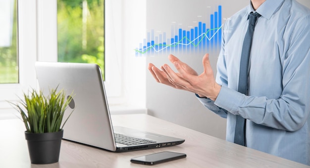 Business man holding tablet and showing holographic graphs and stock market statistics gain profits. Concept of growth planning and business strategy. Display of good economy form digital screen.