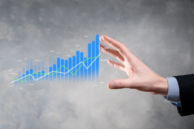 Uomo d'affari che tiene tablet e mostra grafici olografici e statistiche del mercato azionario guadagna profitti. concetto di pianificazione della crescita e strategia aziendale. visualizzazione di uno schermo digitale di buona qualità economica.