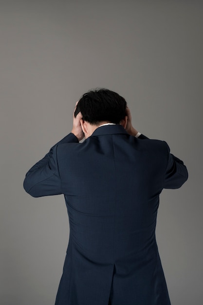 Business man is headache ,grey background in studio 