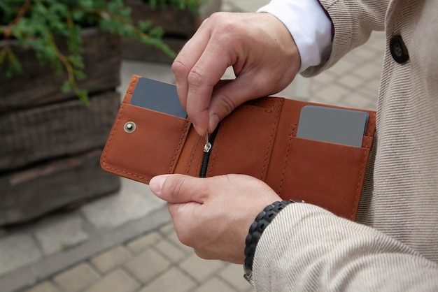 A business man is holding a brown leather wallet