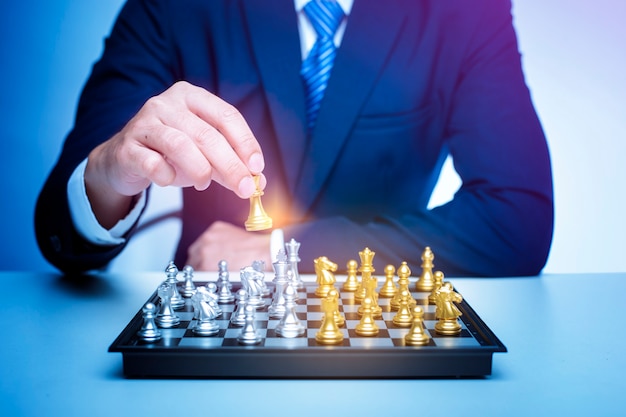 Business man is playing chess, business management strategy concept 