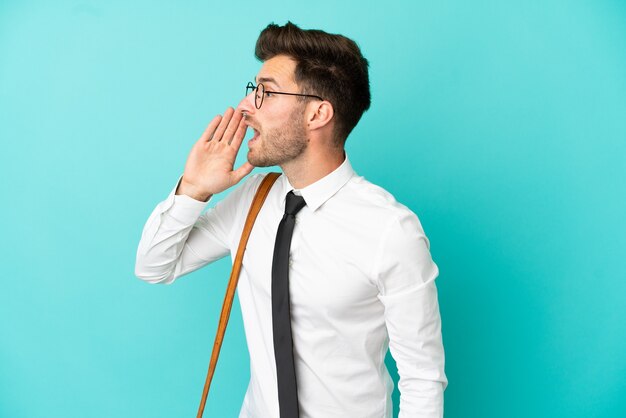 Business man over isolated background shouting with mouth wide open to the lateral