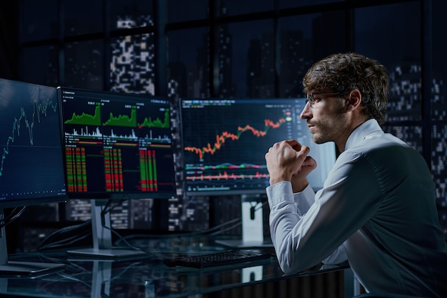 Business man looking at the charts of the stock market of cryptocurrencies on the pc screen