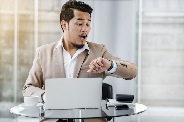 Business man looking watch and shocked with the time