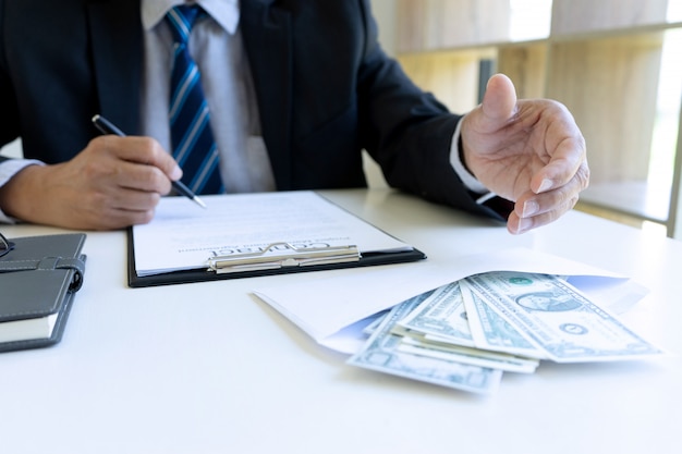 business man at office desk with a bills bundle