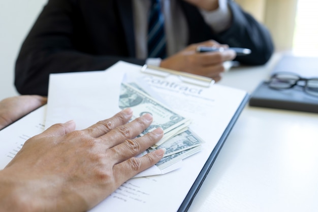 business man at office desk with a bills bundle