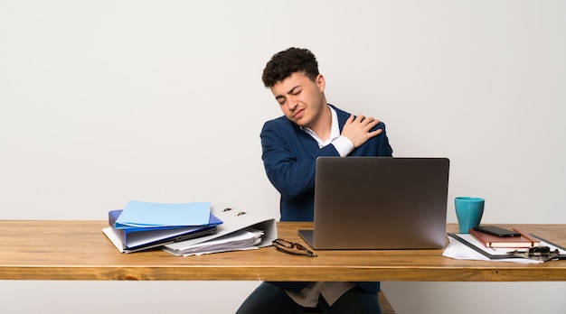 Business man in a office suffering from pain in shoulder for having made an effort