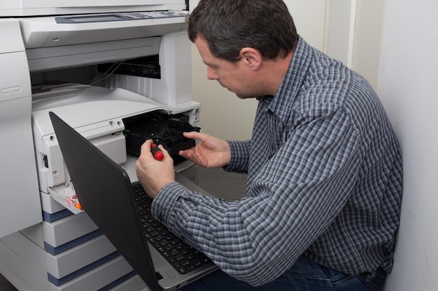 Photo business man opening photocopy machine in office