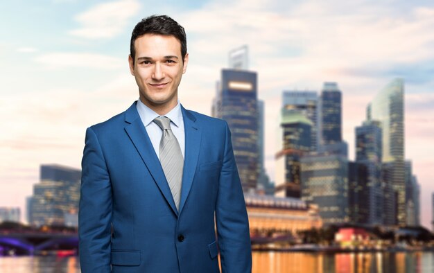 Business man outdoor smiling with a modern skyline in the 