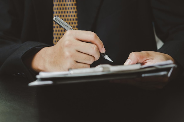 Business man person holding pen sign contract document business lawyer or finance and insurance concept