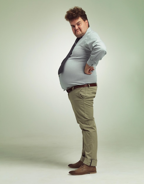 business man portrait and plus size with funny joke and silly in a studio with arms on hips goofy employee and office fashion with fun and modern clothing with green background and humor