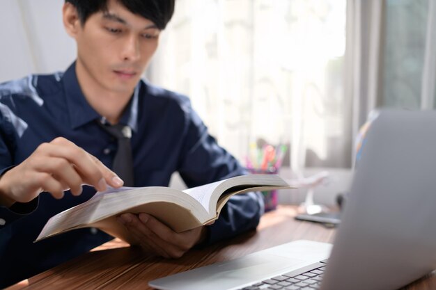 Business man reading a book at his desk