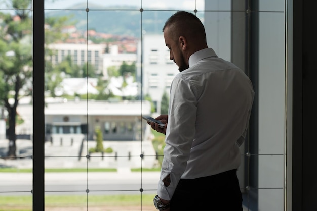 Business Man Reading Text Message On A Mobile In A Modern Office