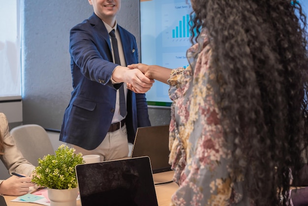 Foto l'uomo d'affari stringe la mano alle donne d'affari che concordano sulle partnership