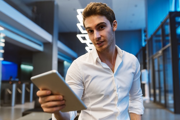 Business man in shirt halding laptop computer in office.