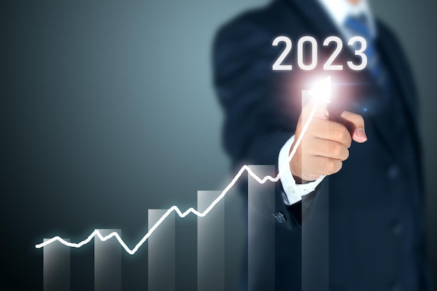 business man signing 2023 profit graph