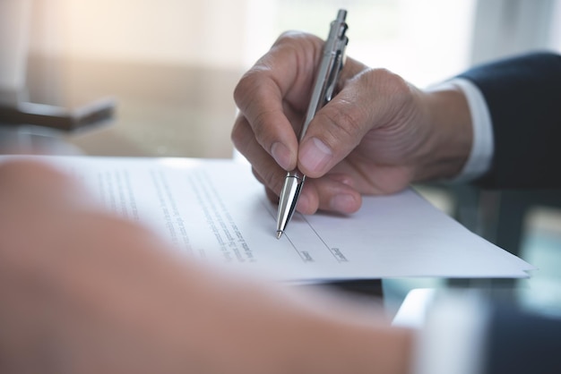 Business man signing official contract formal document with a pen at office