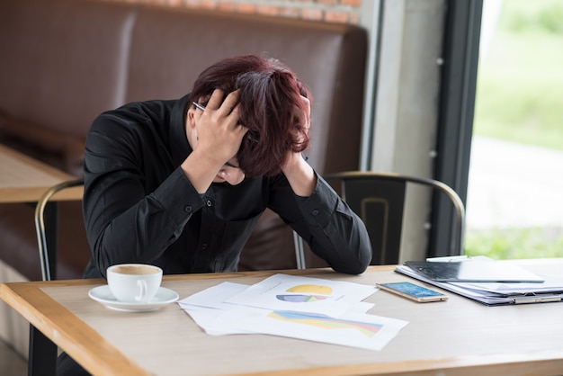  business man sitting in depression with hand on head