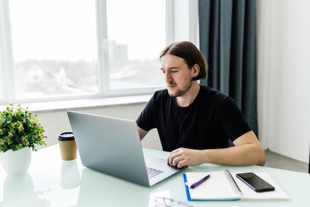 Photo business man sitting at office desk working on laptop computer