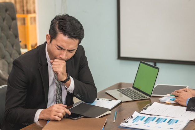 Business man sleepy on working desk between using smartphone , Business concept 