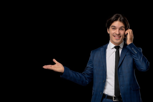 Uomo d'affari sorridente bel ragazzo in abito blu scuro con la cravatta parlando al telefono