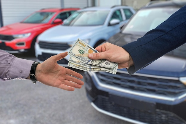 Бизнесмен тратит доллары на покупку или аренду новой машины в современном автосалоне.