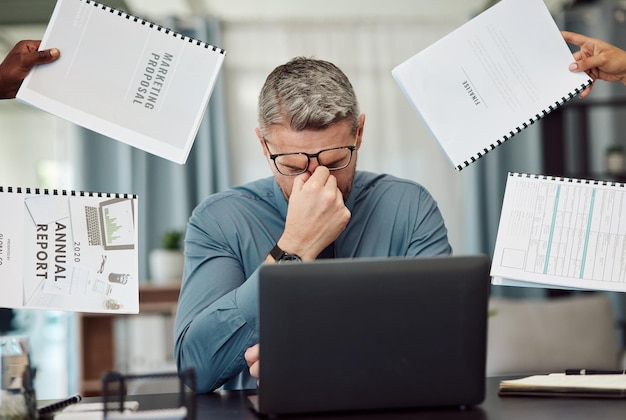 Photo business man stress and overwhelmed with headache documents and staff hands in busy office ceo manager or tired boss with laptop paperwork and burnout with employee group at marketing agency