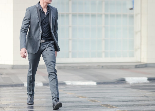 Business man in suit walks on zebra crossing