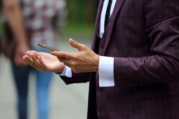 Деловой человек в костюме с мобильным телефоном в руке