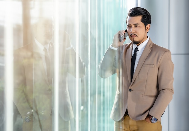 Business man talking with mobile phone in office