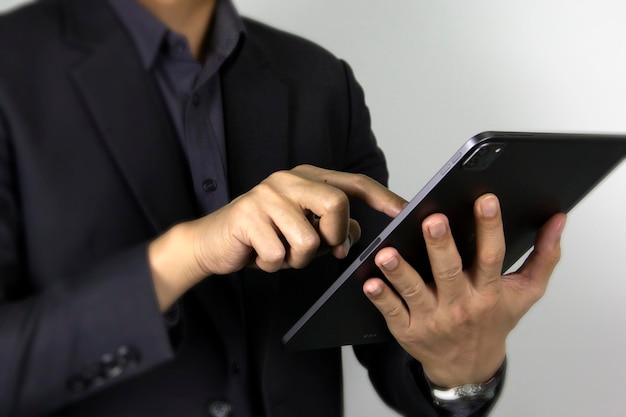 A business man touching on ipad a smart man\'s finger pointing\
on touch screen a technology touch pad