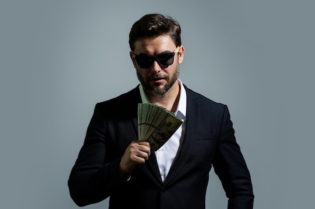 Business man in tshirt with cash money dollars banknotes isolated on yellow studio background hundre