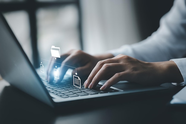 Business man typing on a keyboard with holograms of digital document files data files on computers stored as cloud databases can be viewed online and prevented data loss from the device