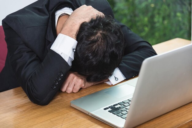 Business man unhappy head down on laptop computer on desk office