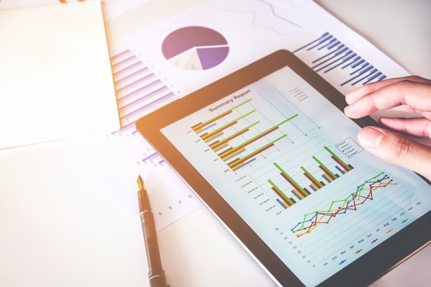 Business man Using digital tablet with Report chart