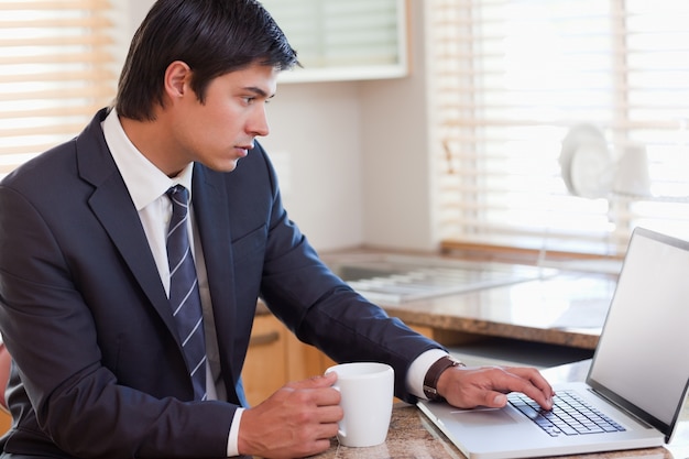 Business man using laptop while having coffee