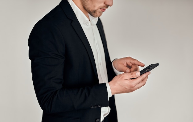 Business man using mobile smart phone isolated on gray background