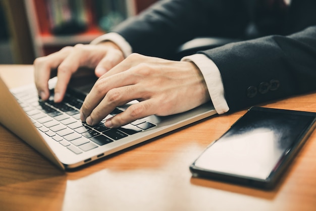 Business man using smart phone and laptop