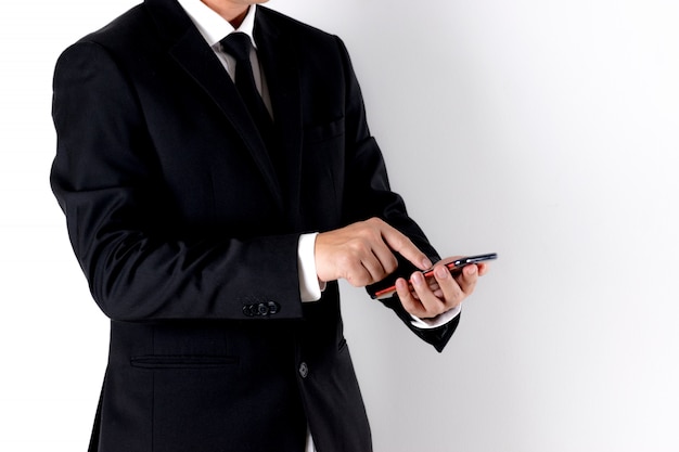 Бизнесмен используя умный телефон над белой предпосылкой с космосом экземпляра для рекламодателей.
