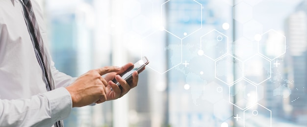 Business man using smart phone on window with futuristic technology connection shape over the network connection background