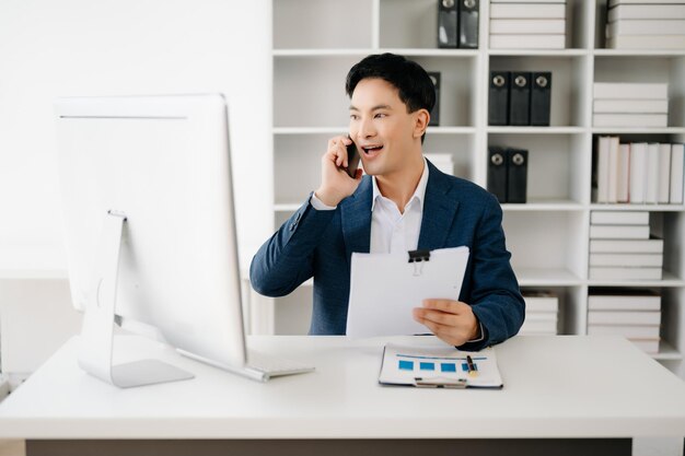 Business man using tablet and laptop for doing math finance on an office desk tax report accounting statistics and analytical research concept in modern office