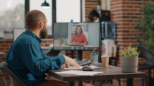 Uomo d'affari che utilizza la videochiamata per parlare con una donna sul computer nell'ufficio di avvio. incontro dell'imprenditore con il manager in videoconferenza online per discutere di pianificazione e strategia del progetto