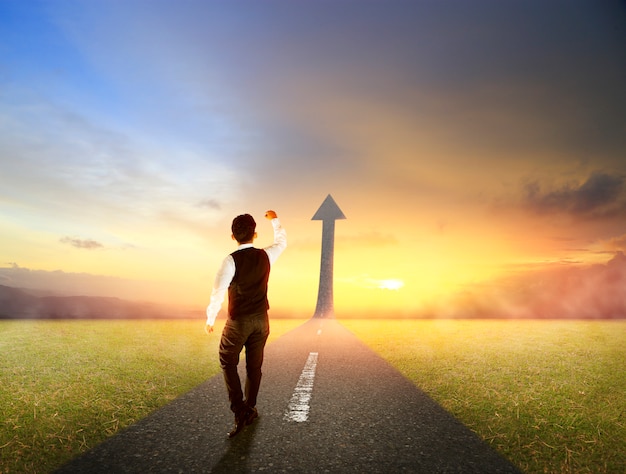 Business man walking on highway road going up as an arrow for success